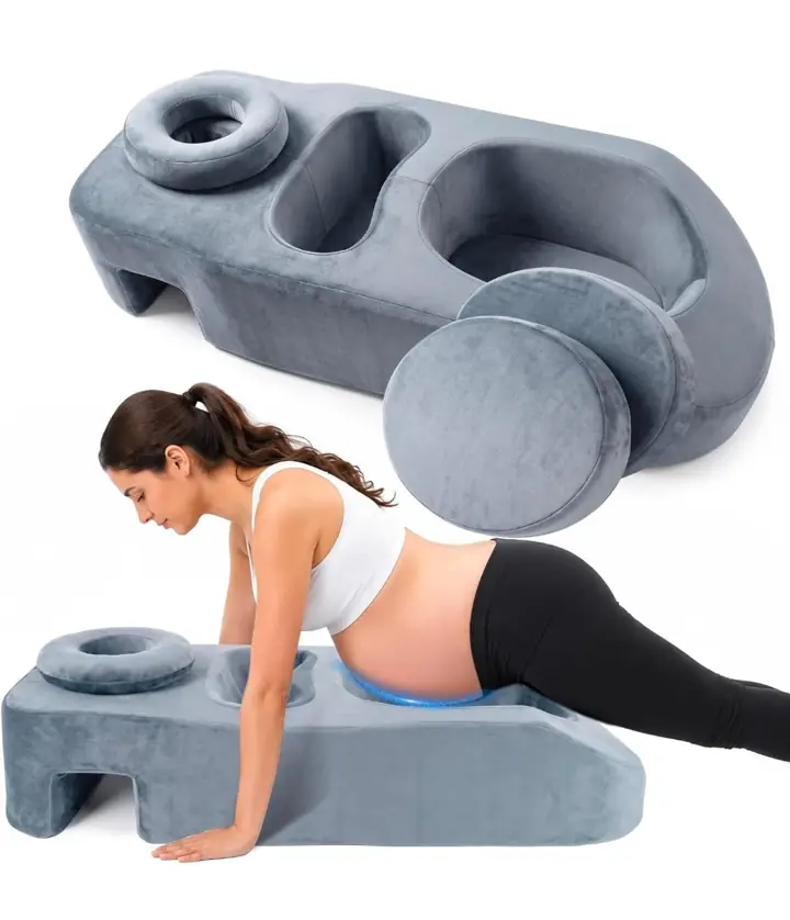 Prenatal massage cushion with a belly cutout, chest recesses and face cradle, shown with an expectant mother resting face-down